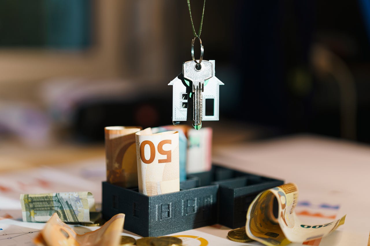 House key over Euro banknotes symbolizes real estate investment and financial planning.
